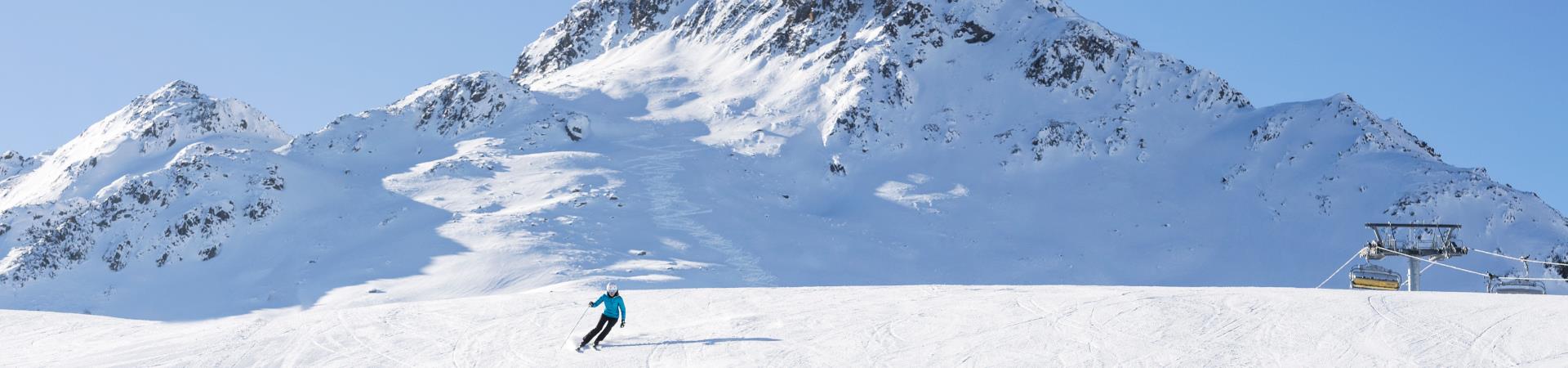 Skifahrerin+auf+Piste+mit+einem+Berg+im+Hintergrund